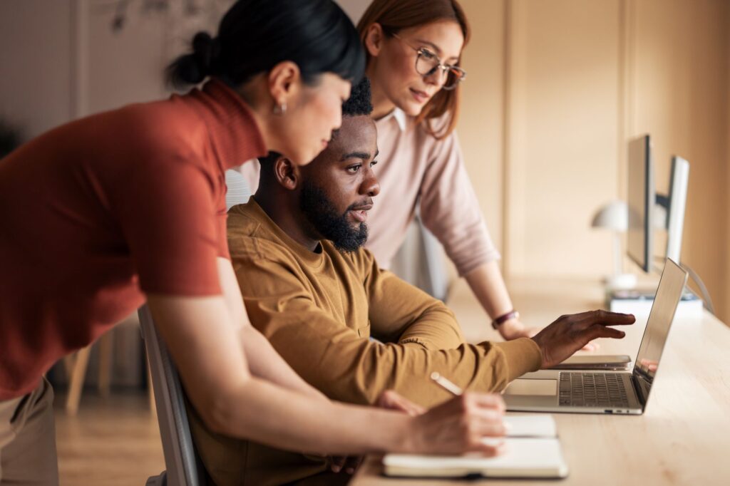 Three colleagues sit in front of a computer depicting a discussion following the 2026 autumn Budget for employment tax changes